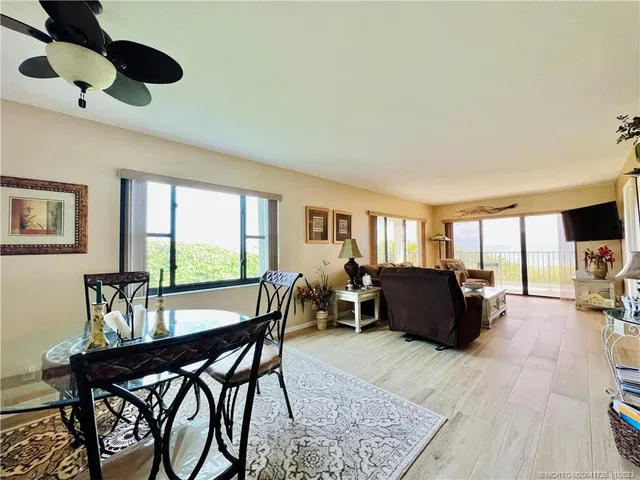 a view of a a dining room with furniture window and wooden floor