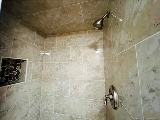 a bedroom with two beds lamp and a window