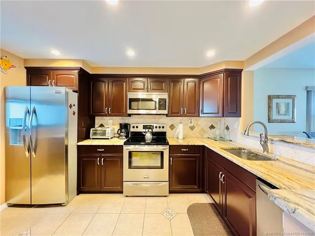 a kitchen with stainless steel appliances granite countertop a stove microwave and oven