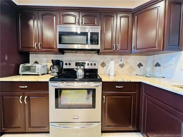 a kitchen with a sink stove top oven and cabinets