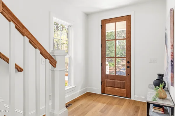 a view of a hallway with wooden floor and staircase