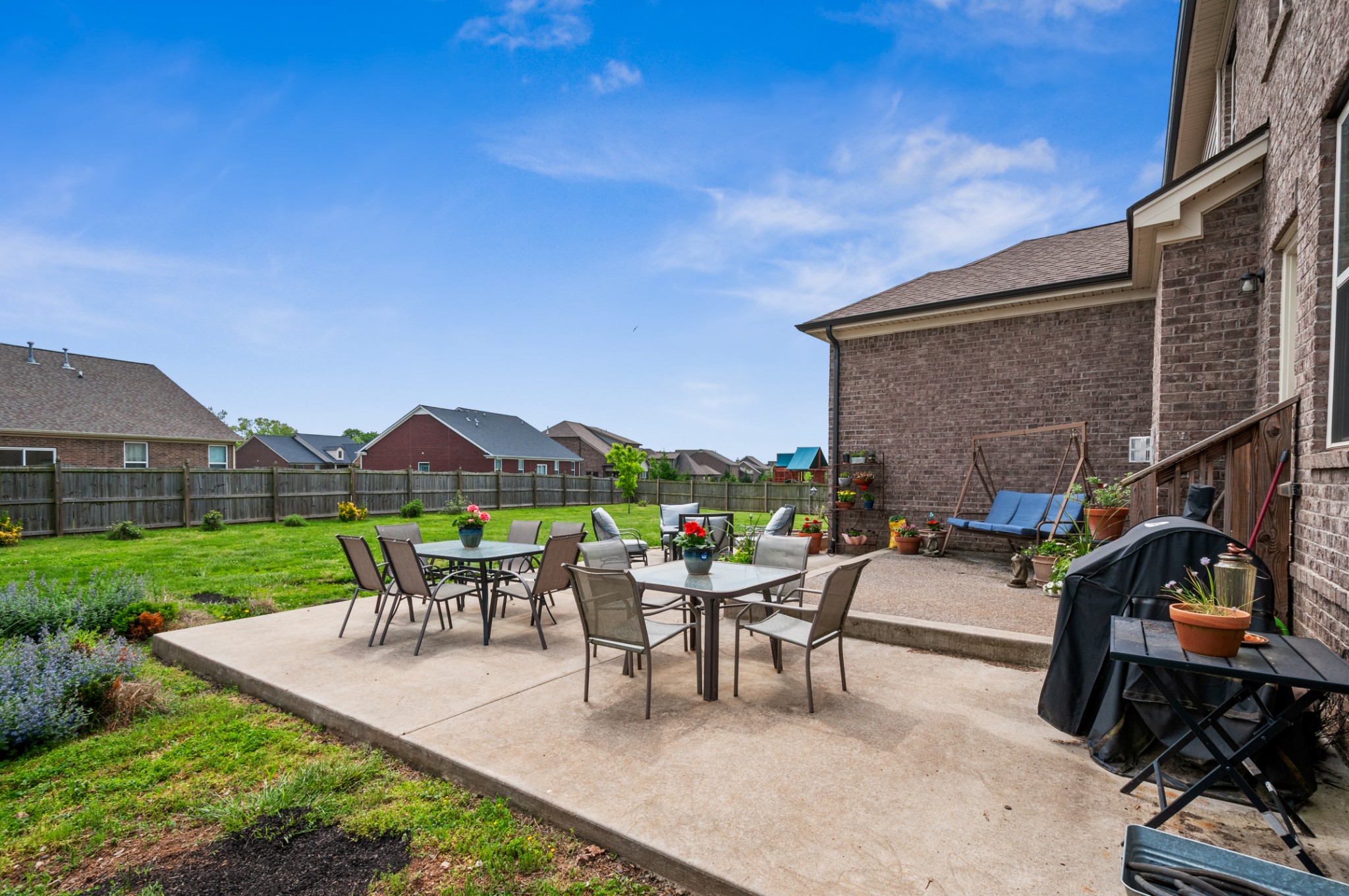 3056 Everleigh Place Spring Hill, TN 37174 - Photo 38 of 43 a view of a patio with couches table and chairs under an umbrella