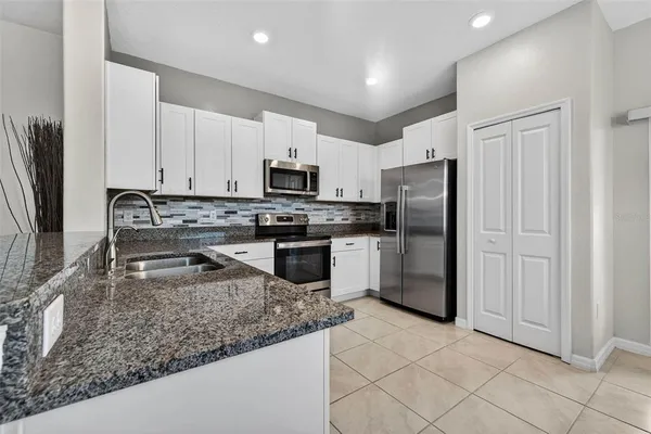 a kitchen with a refrigerator sink and stainless steel appliances