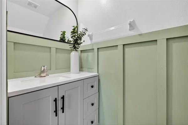 a bathroom with a granite countertop sink a mirror and vanity