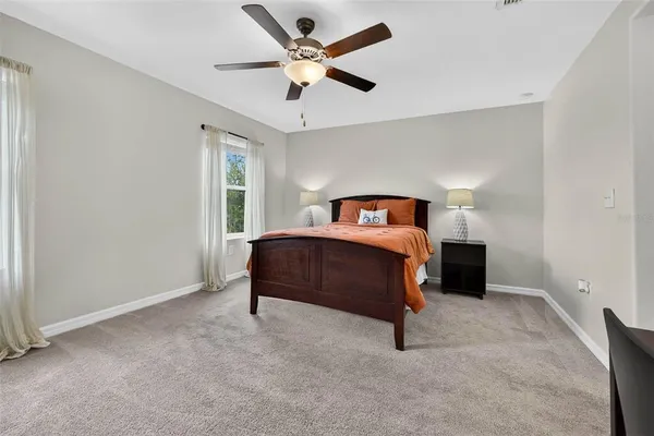 a bedroom with a bed and a ceiling fan