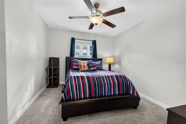 a bedroom with a bed and a ceiling fan