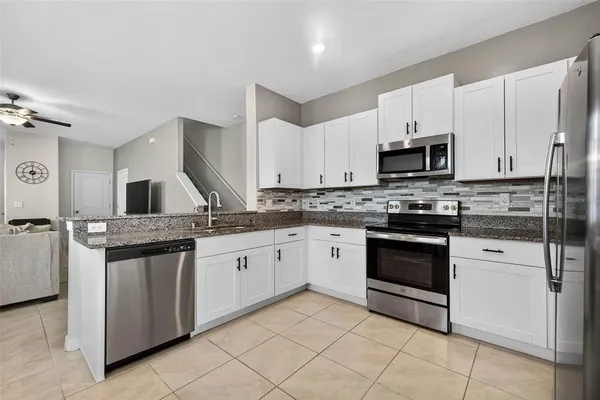 a kitchen with granite countertop a stove sink and cabinets
