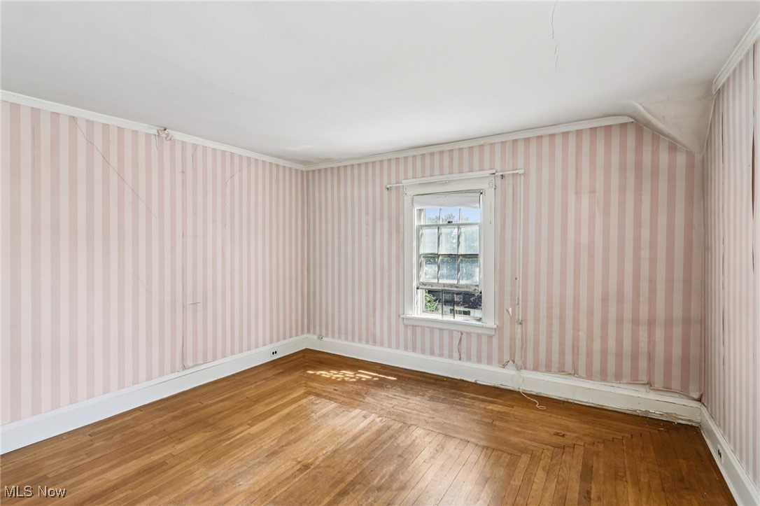 4040 Bayard Road Cleveland, OH 44121 - Photo 41 of 49 Unfurnished room with hardwood / wood-style floors, wallpapered walls, and ornamental molding