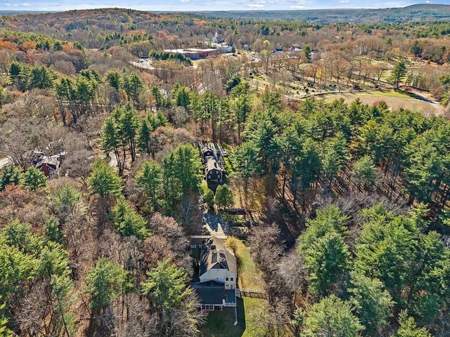 an aerial view of residential houses with outdoor space and trees