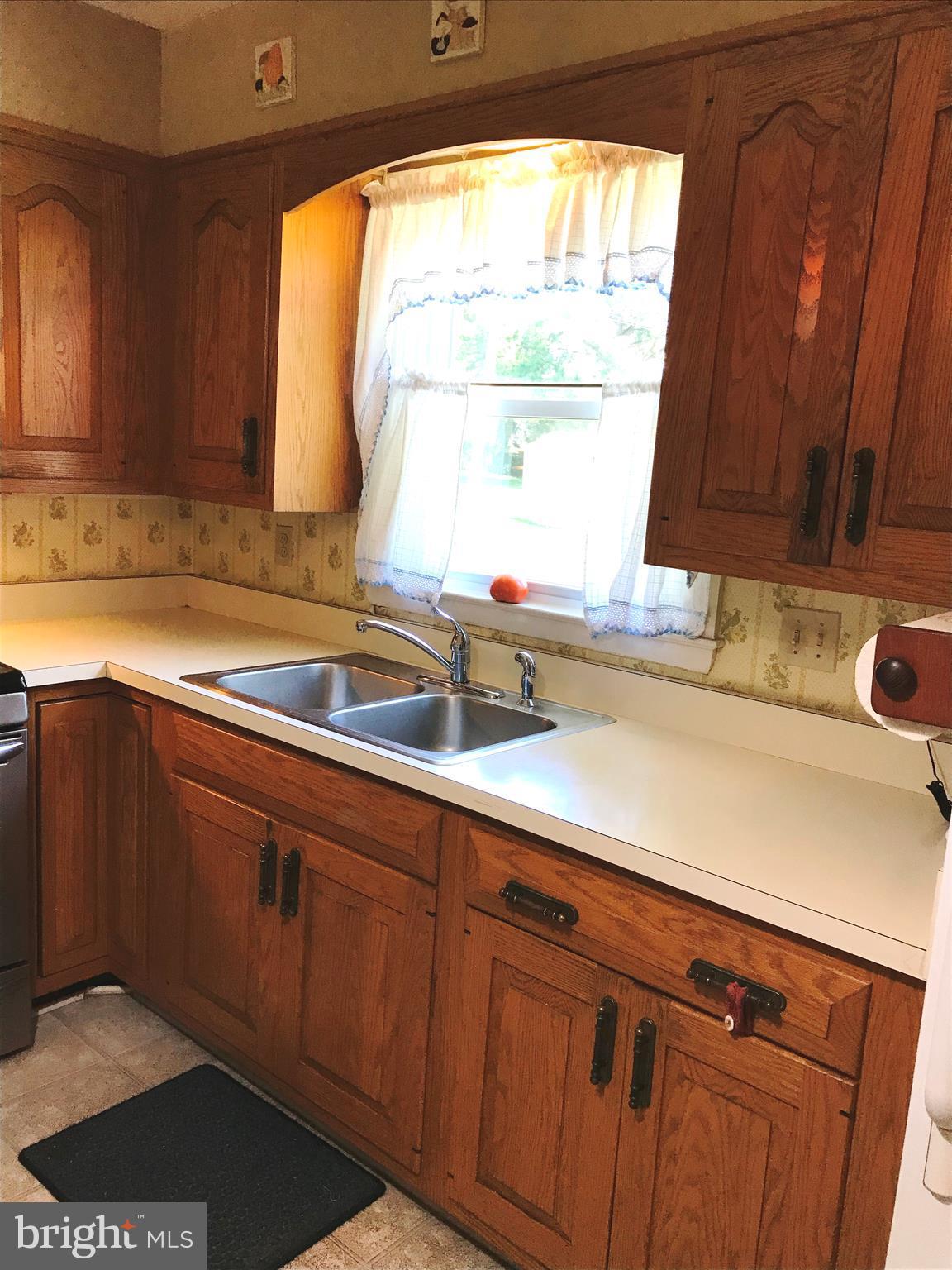 9017 Tammy Road Baltimore, MD 21236 - Photo 8 of 23 a kitchen with stainless steel appliances wooden cabinets a sink and a window