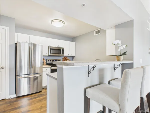 a kitchen with stainless steel appliances a refrigerator and a stove top oven
