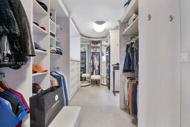 a view of walk in closet with clothes and shoes