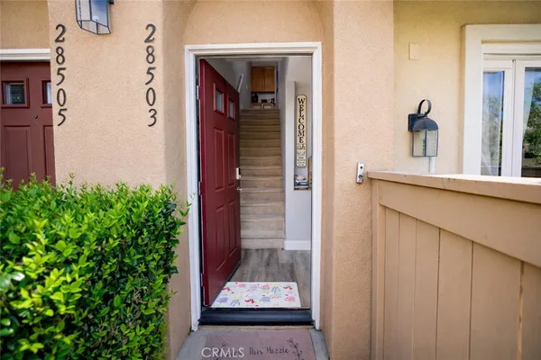 a kitchen with stainless steel appliances granite countertop a stove top oven a sink dishwasher and white cabinets with wooden floor