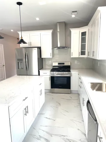 a large kitchen with a stove sink and cabinets