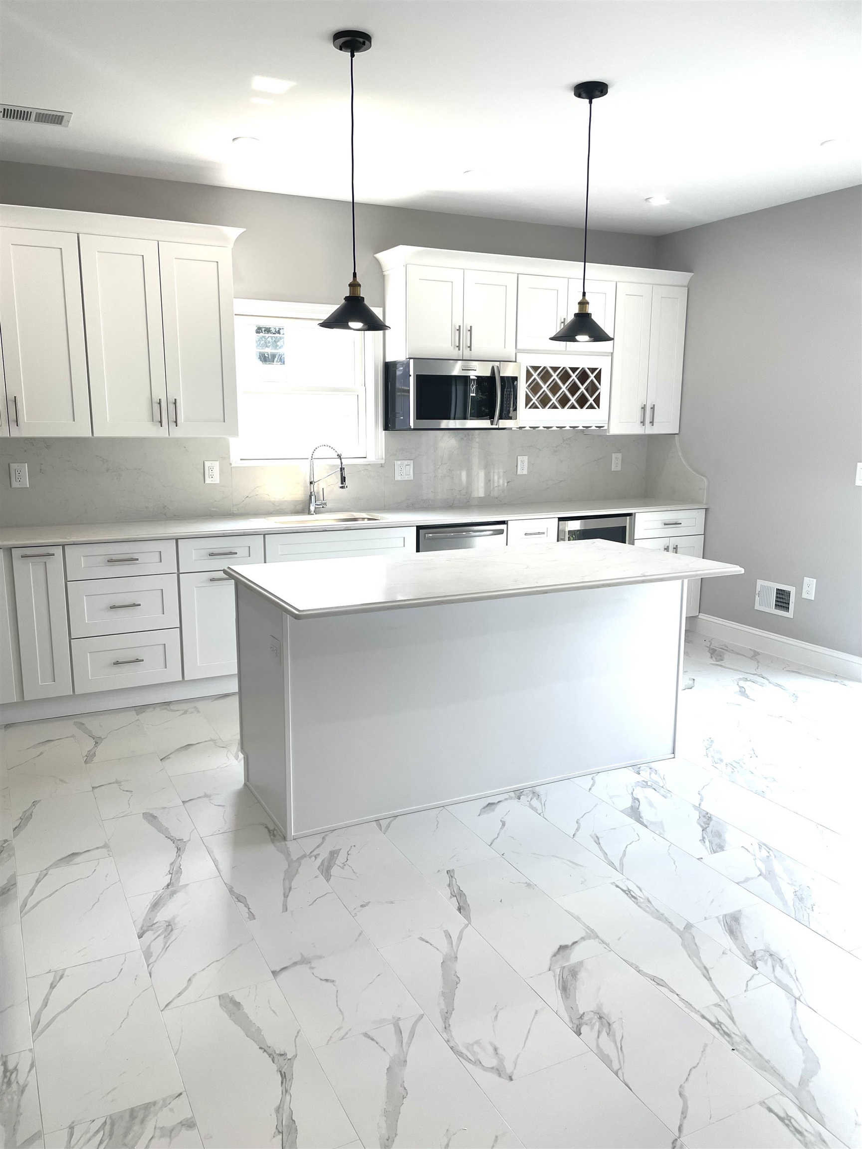 761 B 4th Street, Unit B Secaucus, NJ 07094 - Photo 10 of 34 a kitchen with stainless steel appliances kitchen island granite countertop a sink a stove and white cabinets