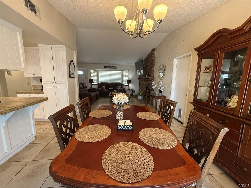 21275 Pocomoke Road Apple Valley, CA 92308 - Photo 14 of 40 a view of a dining room with furniture a chandelier and wooden floor