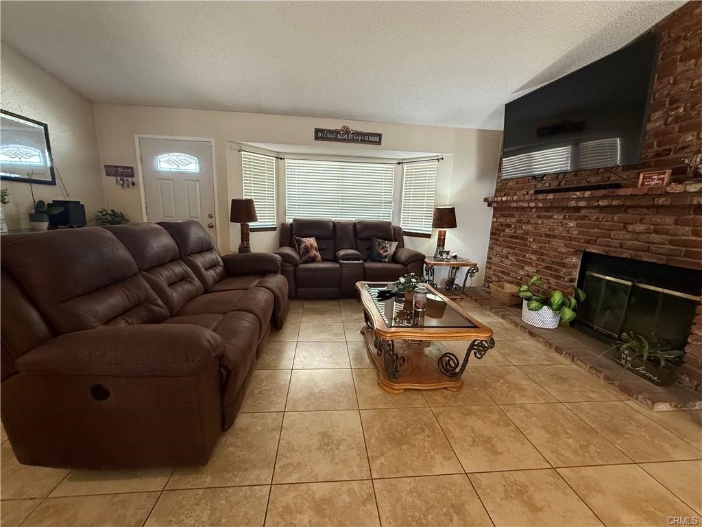 21275 Pocomoke Road Apple Valley, CA 92308 - Photo 15 of 40 a living room with furniture a flat screen tv and a fireplace