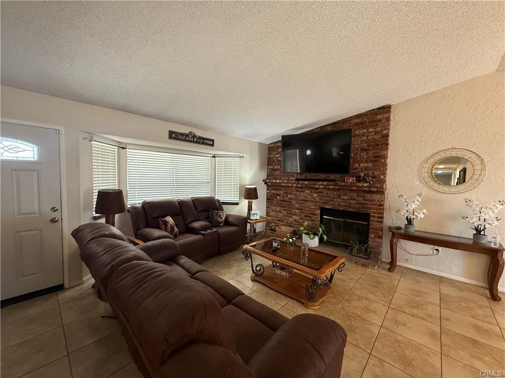 21275 Pocomoke Road Apple Valley, CA 92308 - Photo 17 of 40 a living room with furniture a flat screen tv and a fireplace
