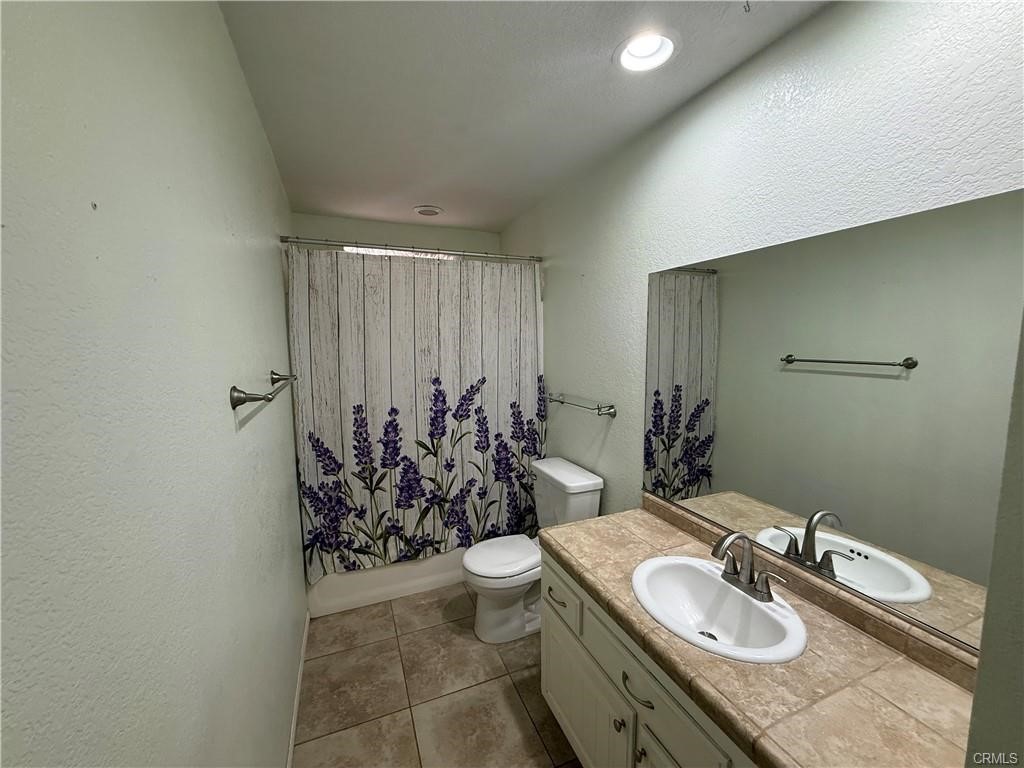 21275 Pocomoke Road Apple Valley, CA 92308 - Photo 18 of 40 a bathroom with a granite countertop sink a toilet a mirror and shower