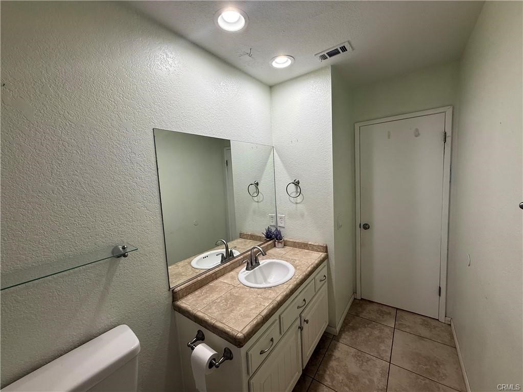 21275 Pocomoke Road Apple Valley, CA 92308 - Photo 19 of 40 a bathroom with a sink a mirror and a toilet