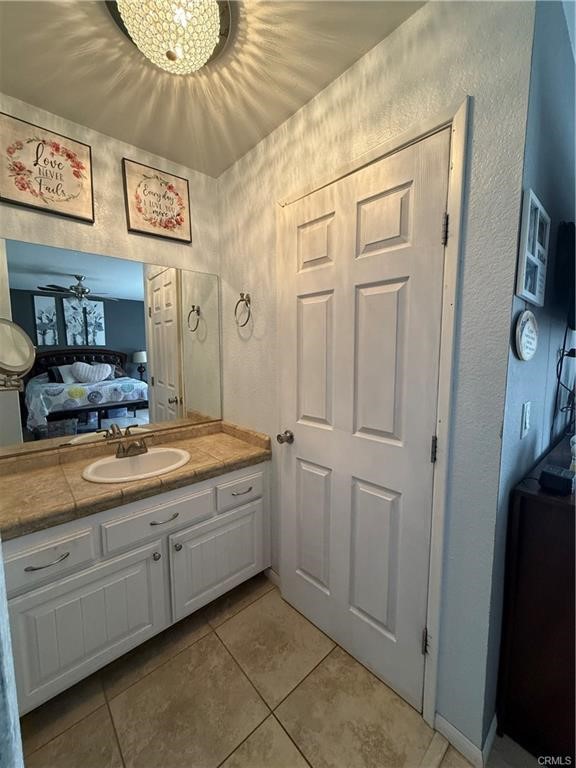 21275 Pocomoke Road Apple Valley, CA 92308 - Photo 29 of 40 a bathroom with a granite countertop sink a mirror and vanity
