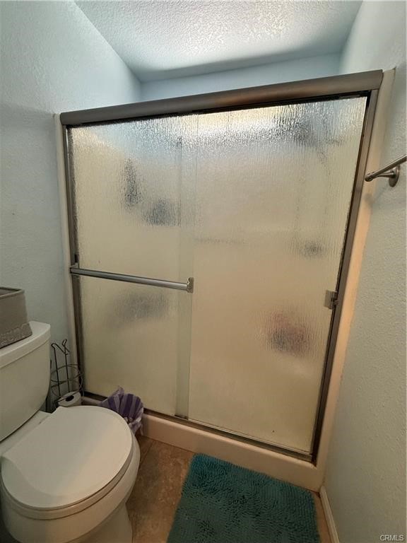 21275 Pocomoke Road Apple Valley, CA 92308 - Photo 30 of 40 a white toilet sitting next to a shower