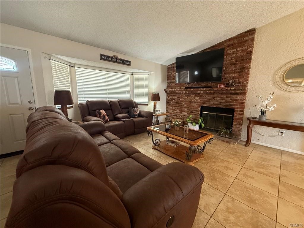 21275 Pocomoke Road Apple Valley, CA 92308 - Photo 7 of 40 a living room with furniture a fireplace and a flat screen tv