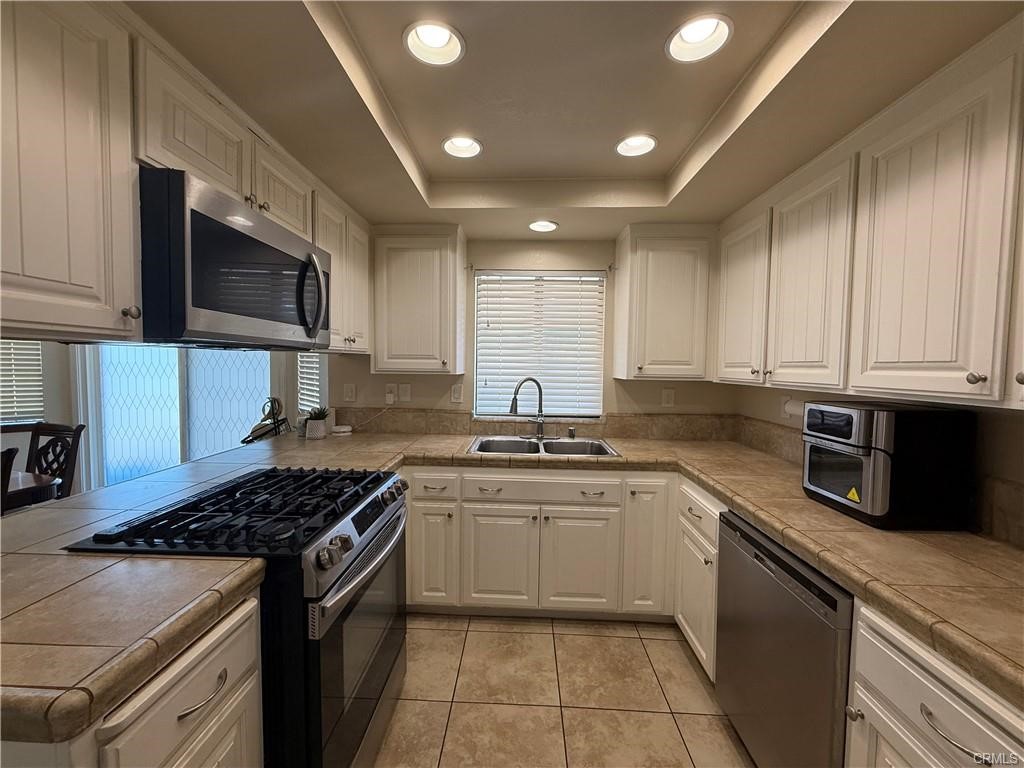 21275 Pocomoke Road Apple Valley, CA 92308 - Photo 10 of 40 a kitchen with stainless steel appliances granite countertop a stove top oven a sink dishwasher and a microwave oven with large cabinets