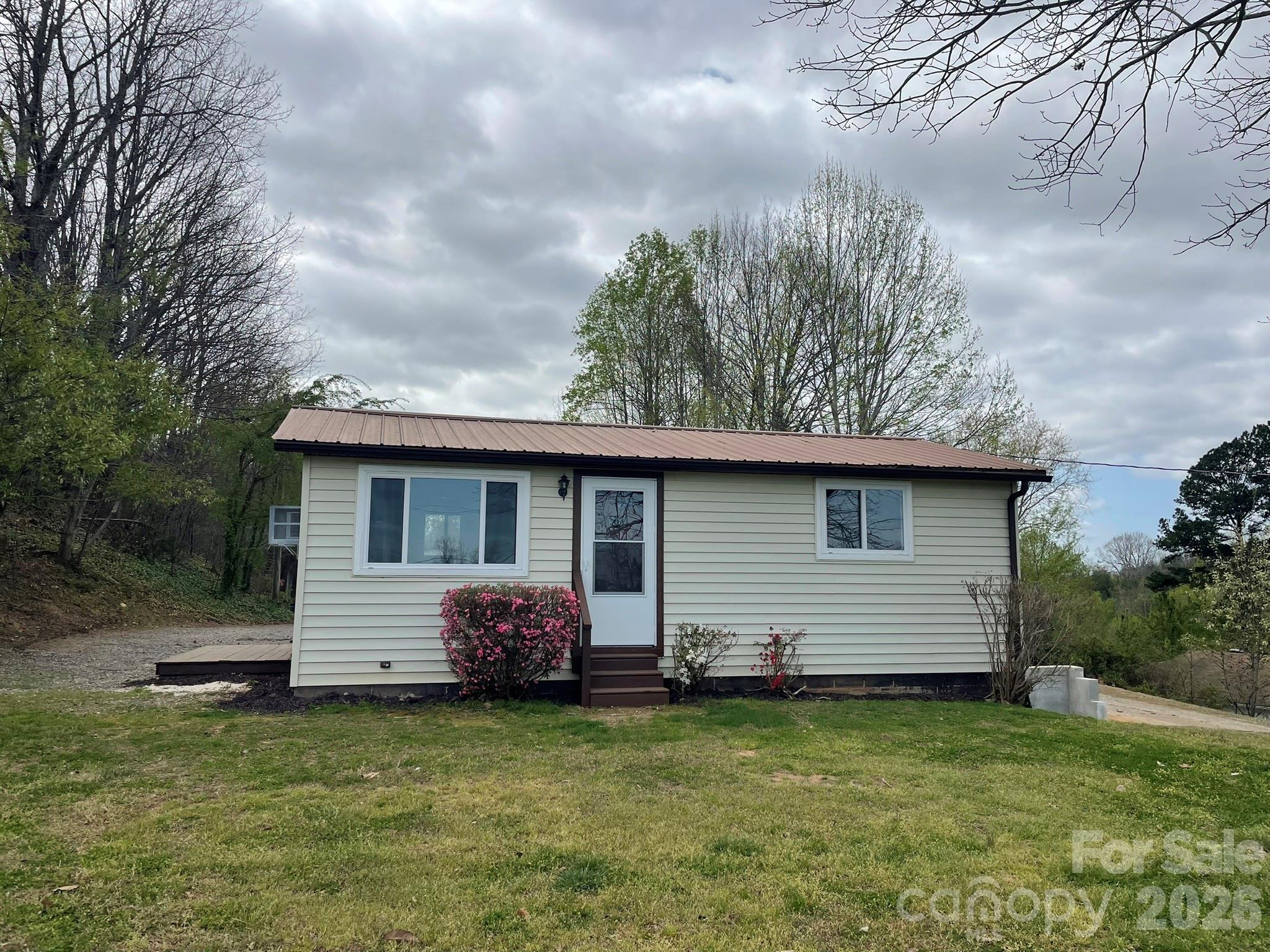 7686 Shoupes Grove Church Road Hickory, NC 28602 - Photo 20 of 36 a front view of house with yard and trees in the background