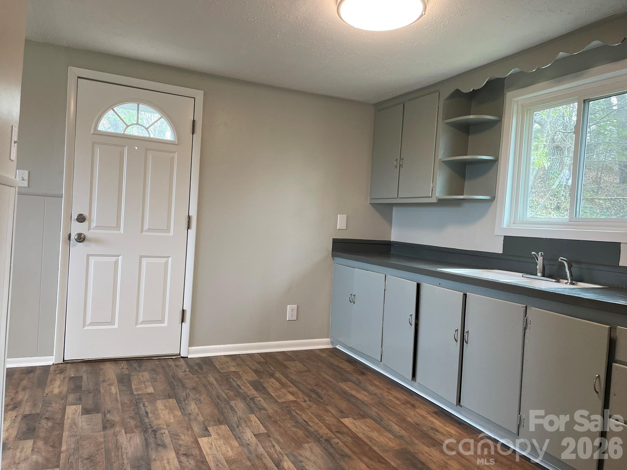 7686 Shoupes Grove Church Road Hickory, NC 28602 - Photo 26 of 36 an empty room with wooden floor cabinet and windows