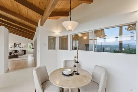 a porch with seating space and trees in the background