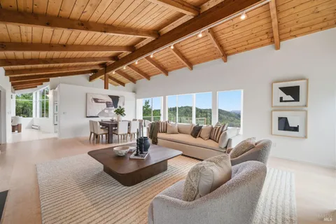 a living room with fireplace furniture and a large window