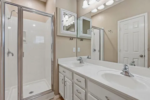 a bathroom with double vanity sink and a mirror