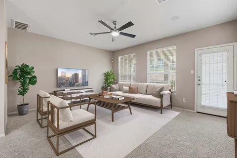 a living room with furniture a ceiling fan and a window