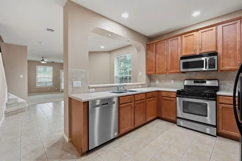a kitchen with stainless steel appliances granite countertop a stove top oven microwave and sink