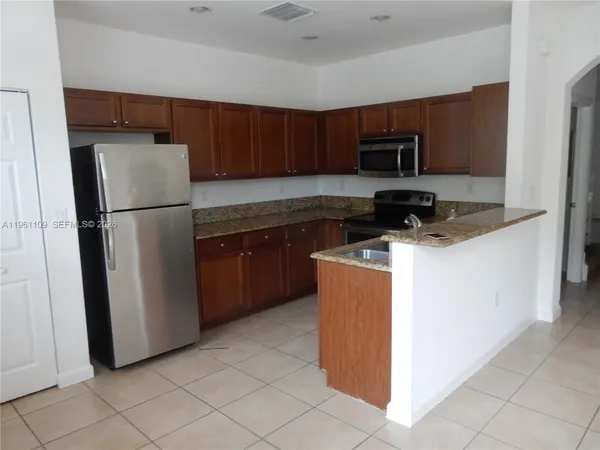 a kitchen with stainless steel appliances a stove a sink and a microwave