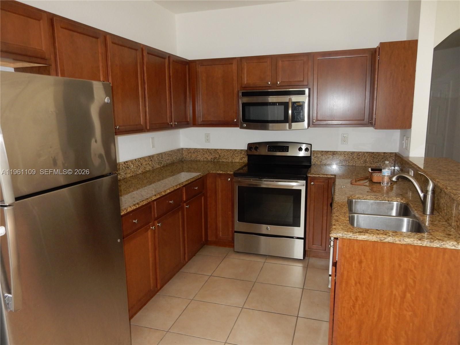 3467 West 89th Terrace Hialeah, FL 33018 - Photo 29 of 33 a kitchen with a refrigerator stove and microwave