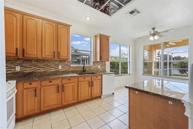 a large kitchen with stainless steel appliances granite countertop a stove a sink and a refrigerator