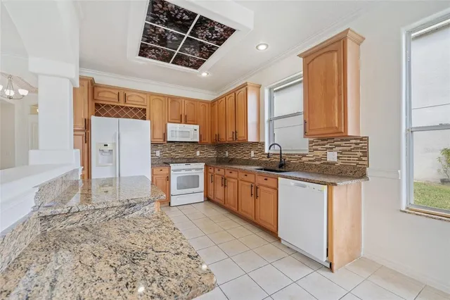 a kitchen with stainless steel appliances granite countertop a stove a sink and a refrigerator