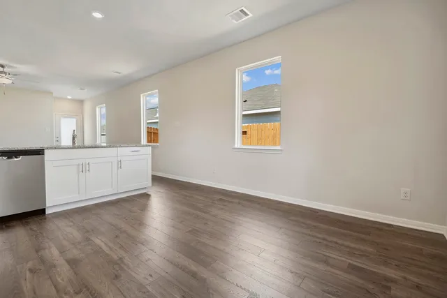 a view of a kitchen with wooden floor and windows