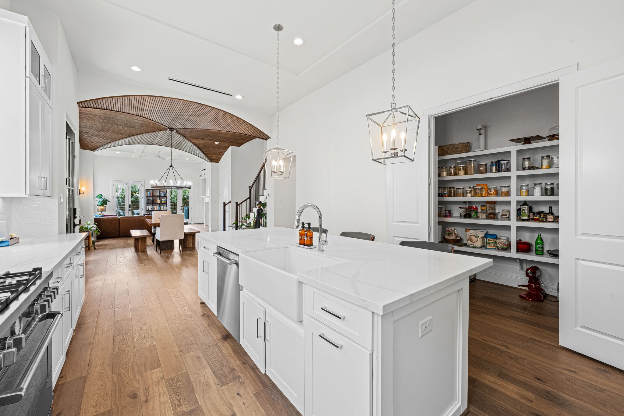 533 West 27th Street Houston, TX 77008 - Photo 4 of 22 The oversized quartz island offers generous bar seating beneath lantern-style pendant lighting, while a spacious walk-in pantry and seamless connection to the dining and living areas make the kitchen as functional as it is inviting.