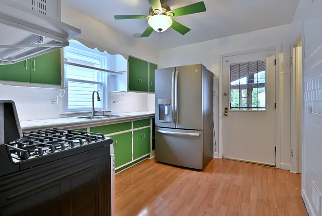 a kitchen with green cabinets and a stove top oven