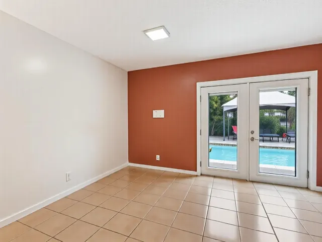 a view of an empty room with window and stairs
