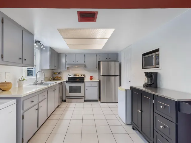 a kitchen with a refrigerator sink and cabinets