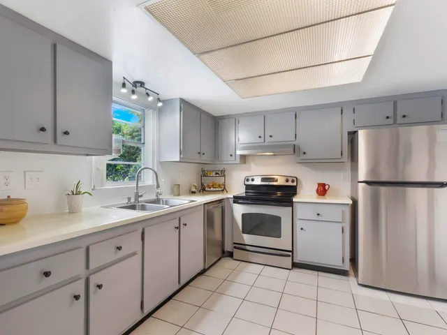 a kitchen with white cabinets and white appliances