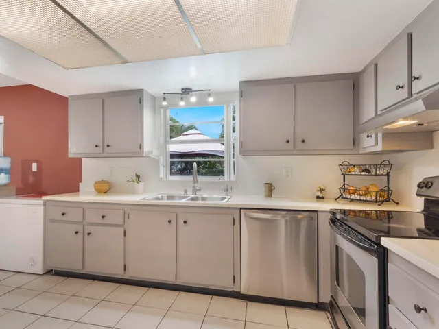 a kitchen with white cabinets and sink
