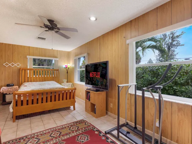 a bedroom with a bed window and a flat screen tv