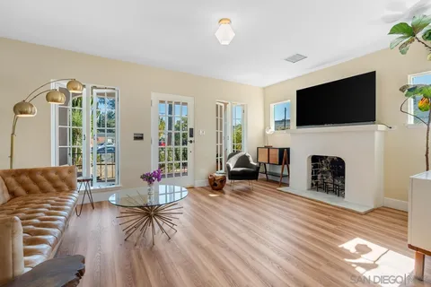 a living room with furniture a flat screen tv and a fireplace