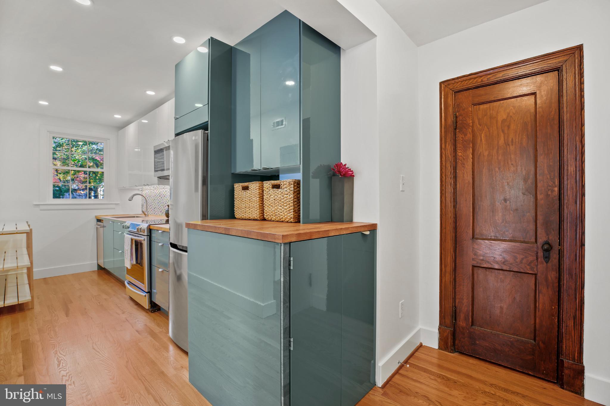 318 Rhode Island Avenue Northeast, Unit 101 Washington, DC 20002 - Photo 14 of 33 a kitchen with kitchen island wooden floor and refrigerator
