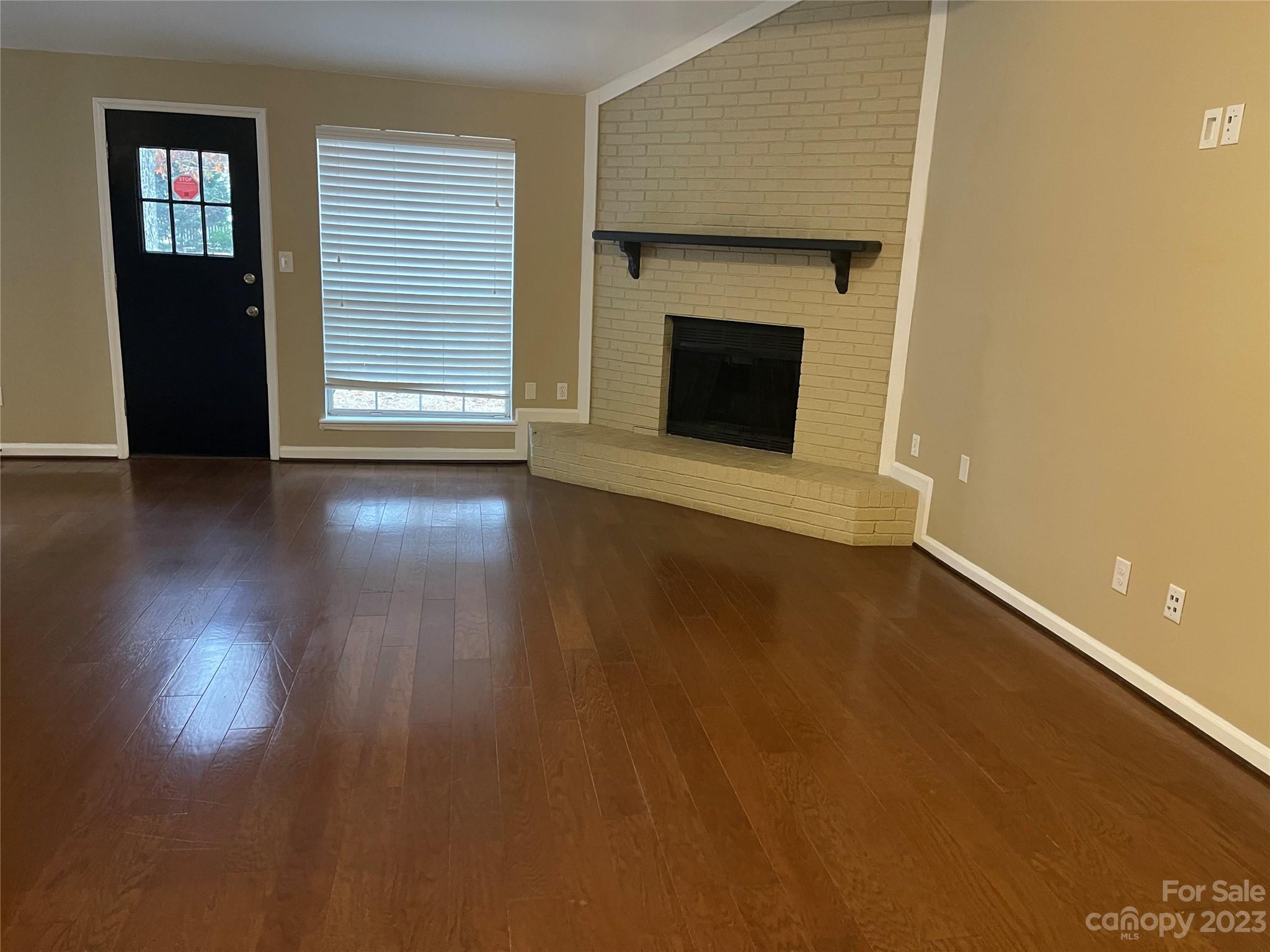10427 Fairway Ridge Road Charlotte, NC 28277 - Photo 4 of 21 an empty room with wooden floor fireplace and windows
